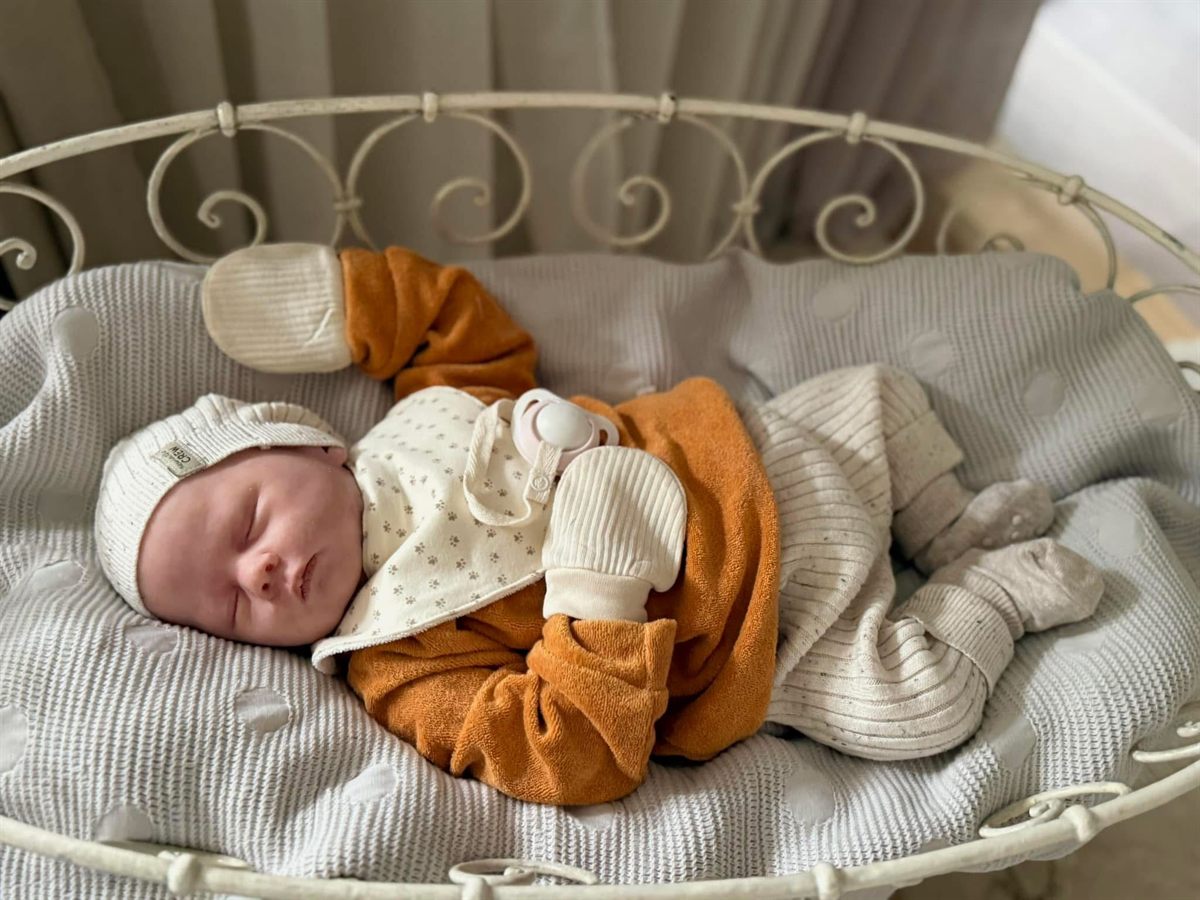 Teilsilikon-Baby Neele, 50 cm, schlafend in gestrickter Kleidung im Bettchen